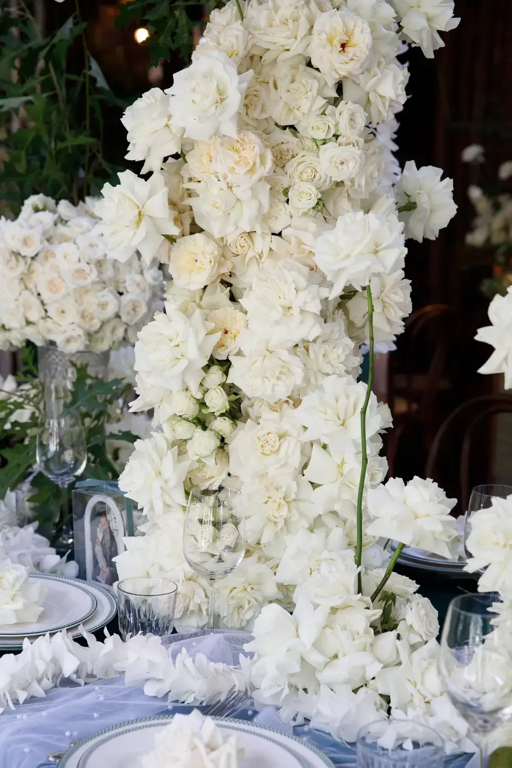 White rose floral centrepiece arrangement on styled christening table with elegant place settings