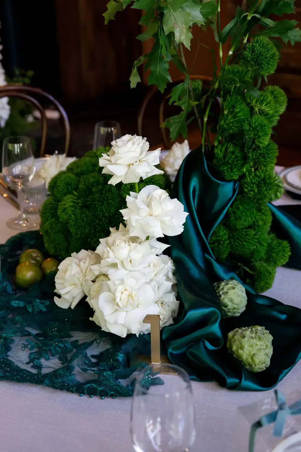 Close-up christening table styling with white roses, green moss details and elegant table decor