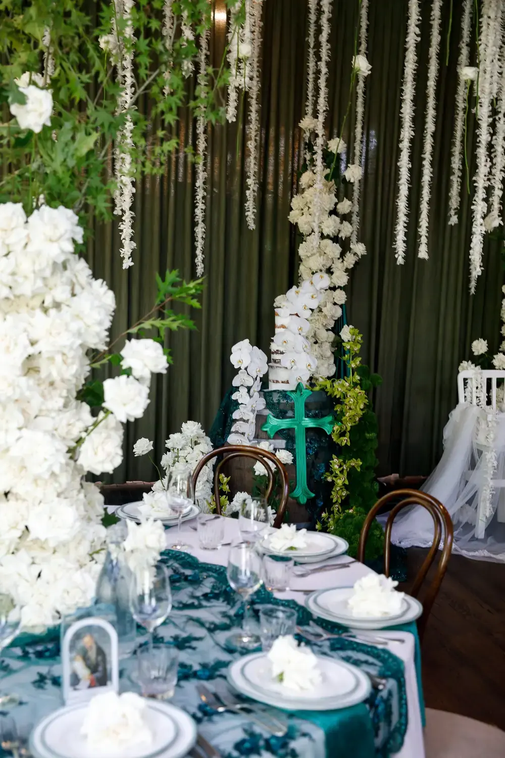 Luxury christening reception table with white floral arrangements and hanging floral installations
