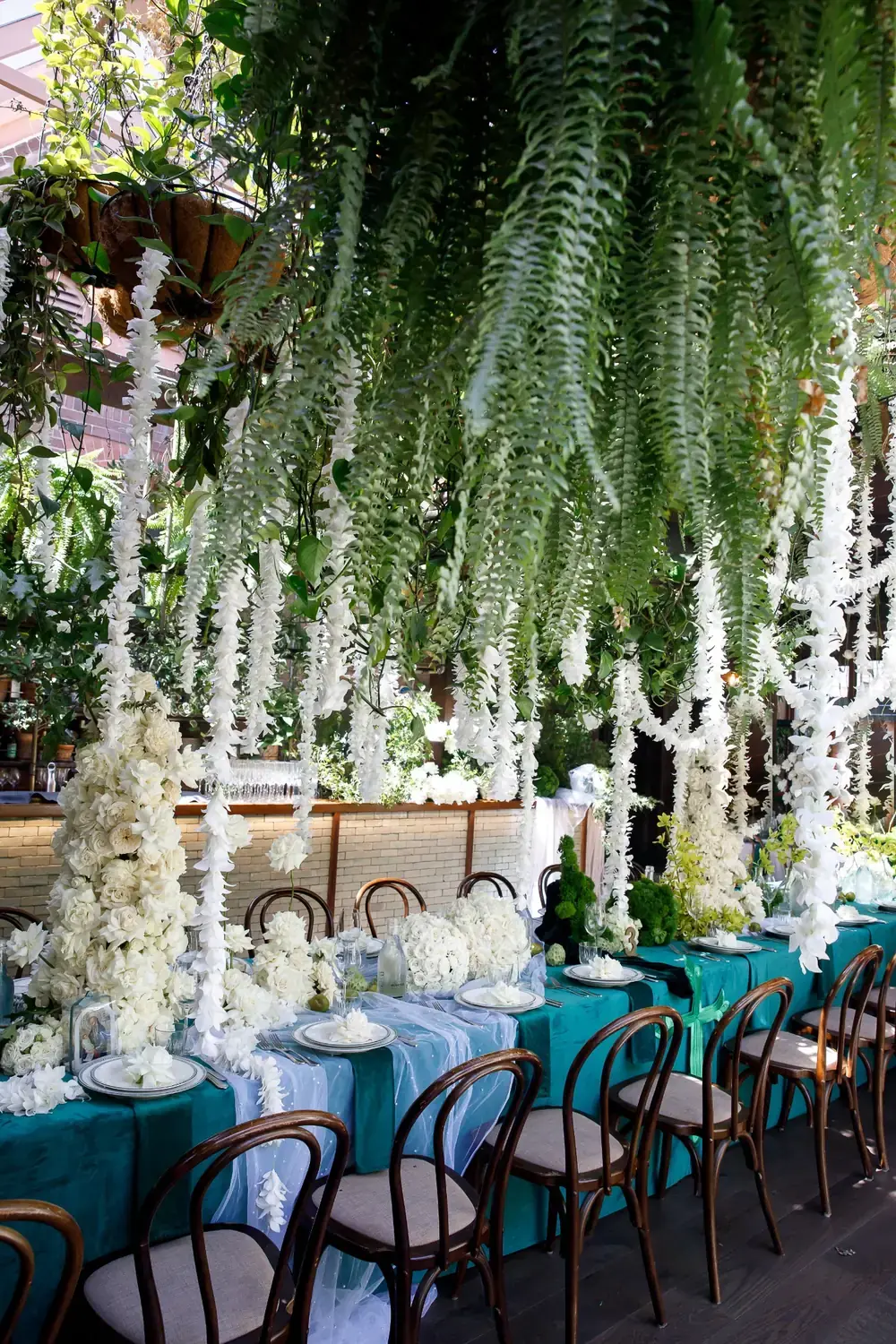 Overhead hanging greenery and white floral installations creating luxury christening event styling