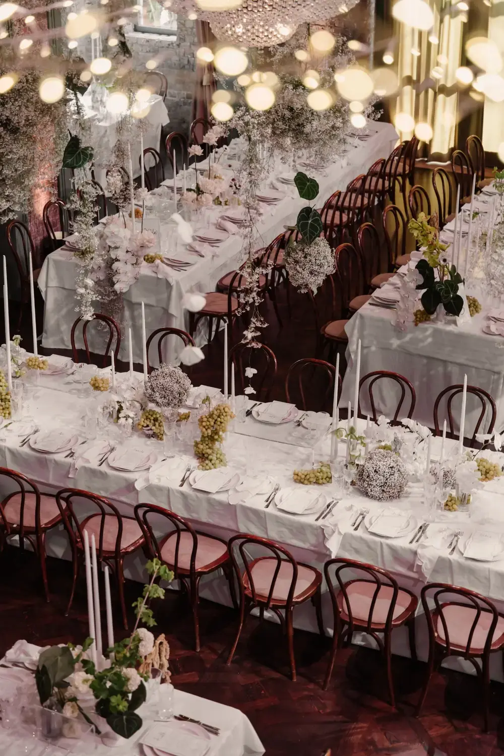 Overhead view of wedding reception tables with white flowers, candles and luxury styling at Linseed House
