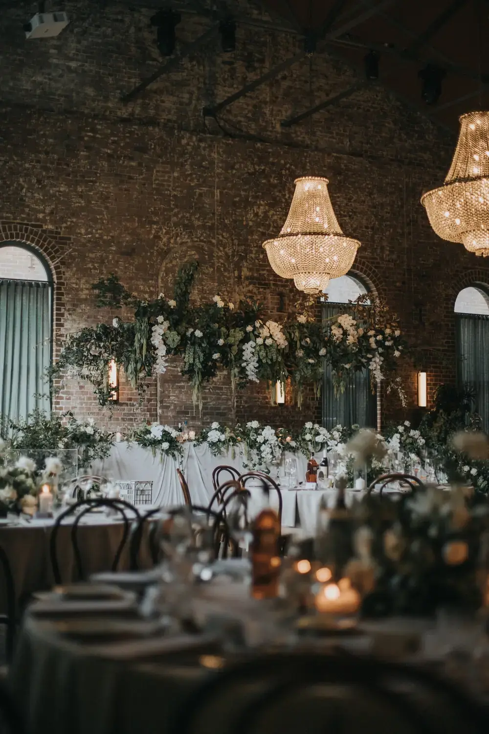 Hanging greenery installation and chandelier styling with romantic wedding flowers at Linseed House venue