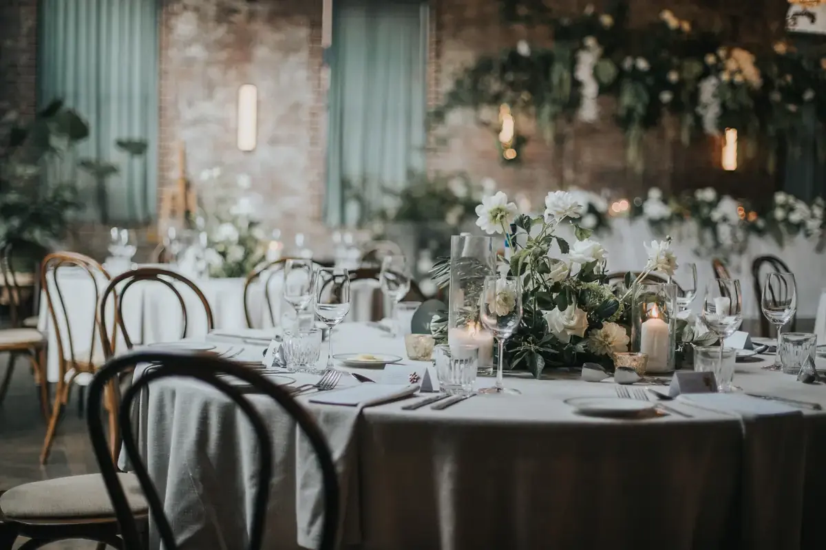 Close-up of wedding flowers centrepiece with white blooms and candlelight on reception table